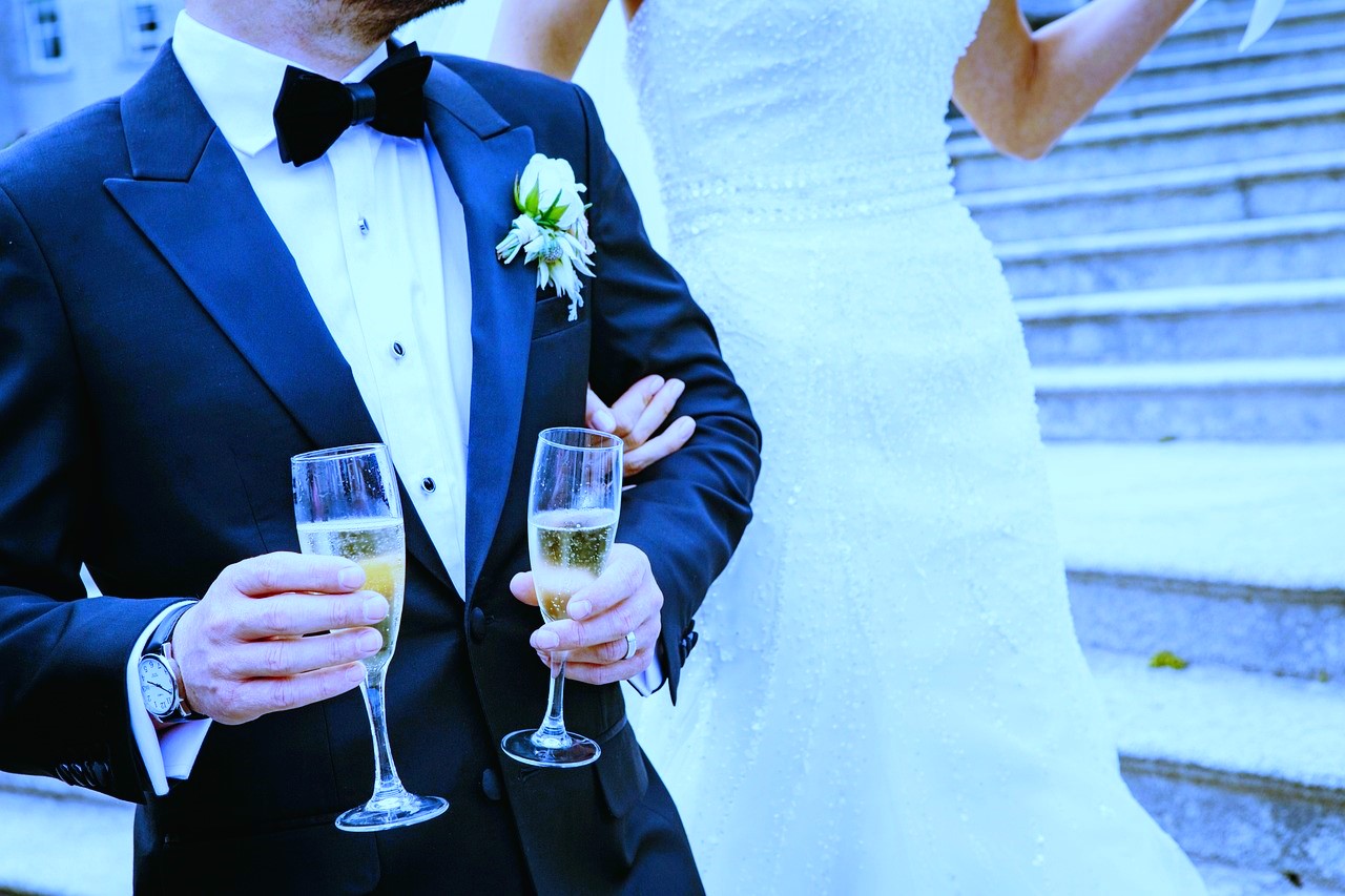 bride and groom holding English sparkling wine in glasses